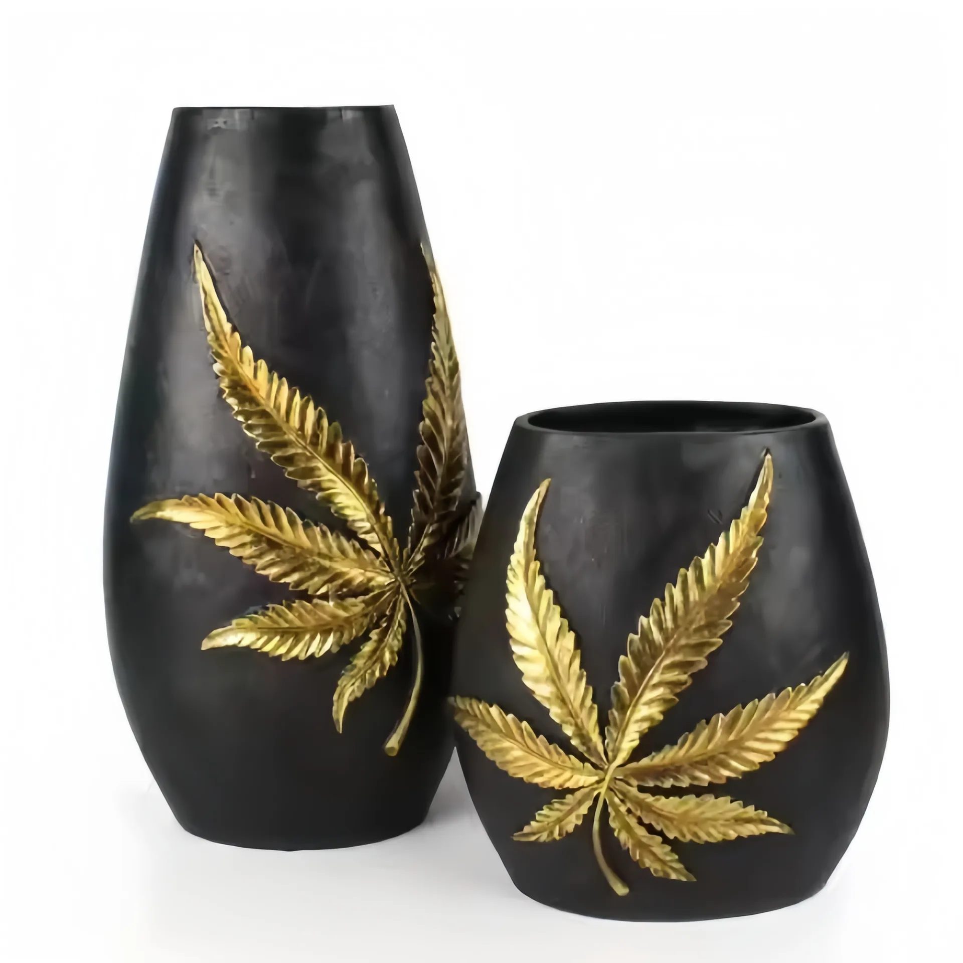 Zwei schwarze Vasen mit goldenen Cannabisblättern verziert.