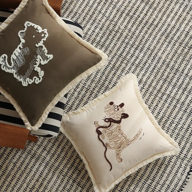 Deux coussins avec des motifs de broderie d'animaux sur un sol texturé.