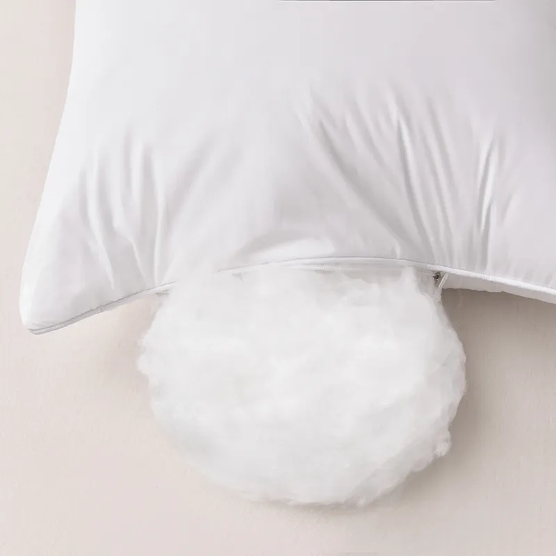 A white pillow with filling exposed through an open zipper.