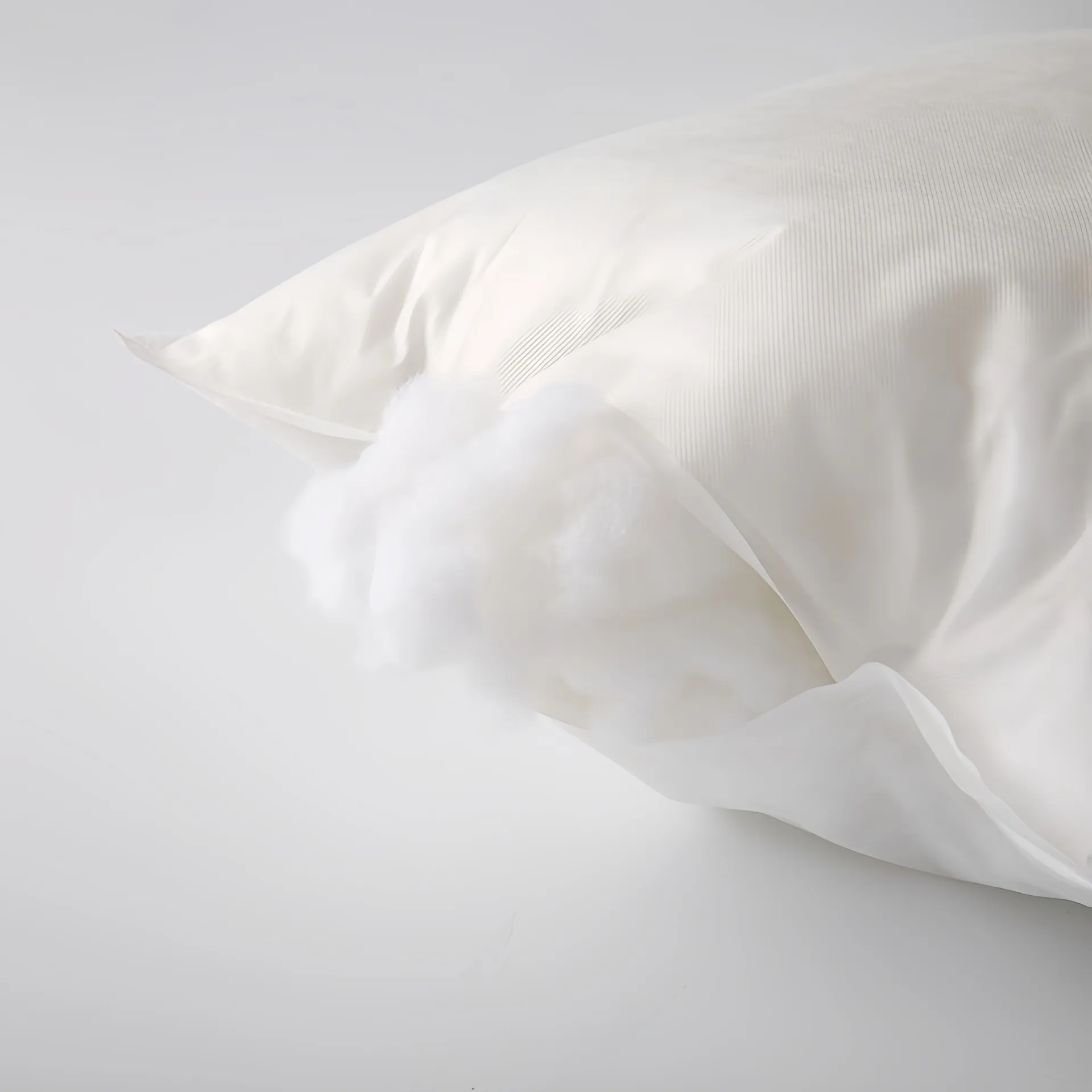 A white pillow with its soft stuffing partially exposed.