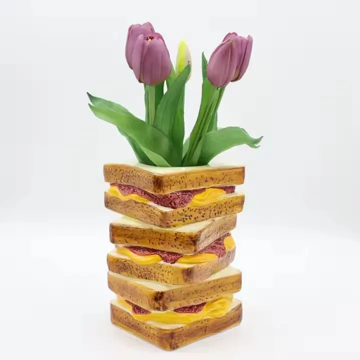 Stack of sandwich slices serving as a vase for purple tulips.