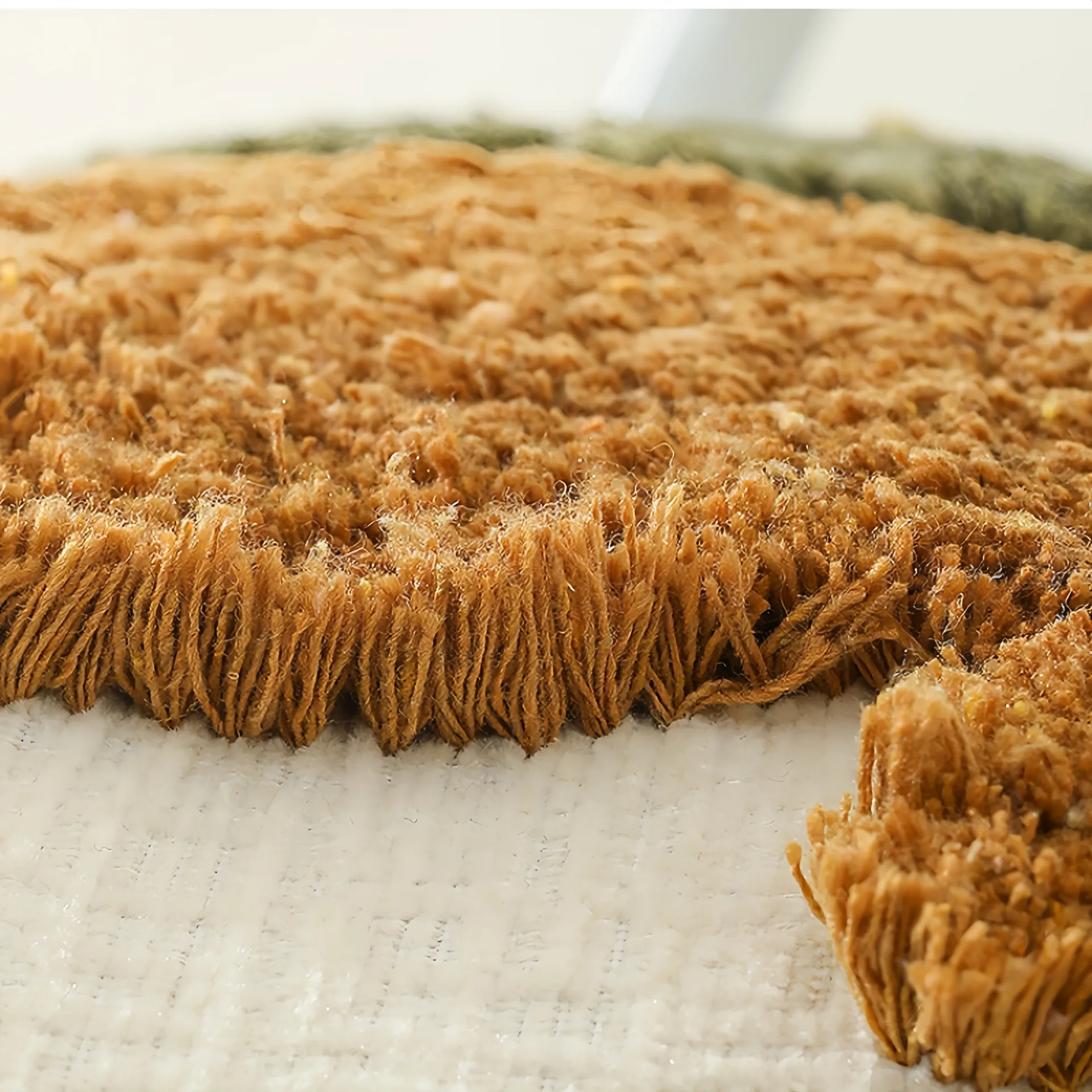 Close-up view of a textured brown rug with detailed fibers.