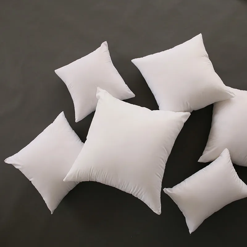 A collection of white cushions arranged on a dark surface.