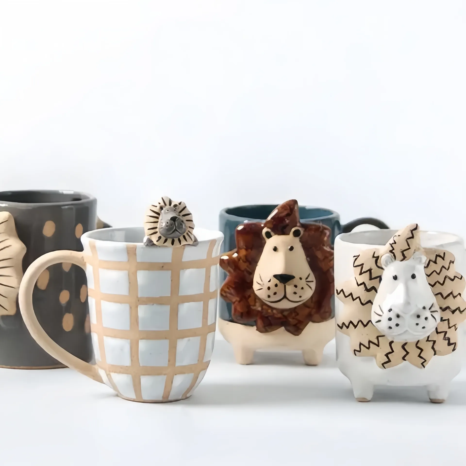 A collection of handmade mugs with animal designs, featuring lions and other animal motifs.