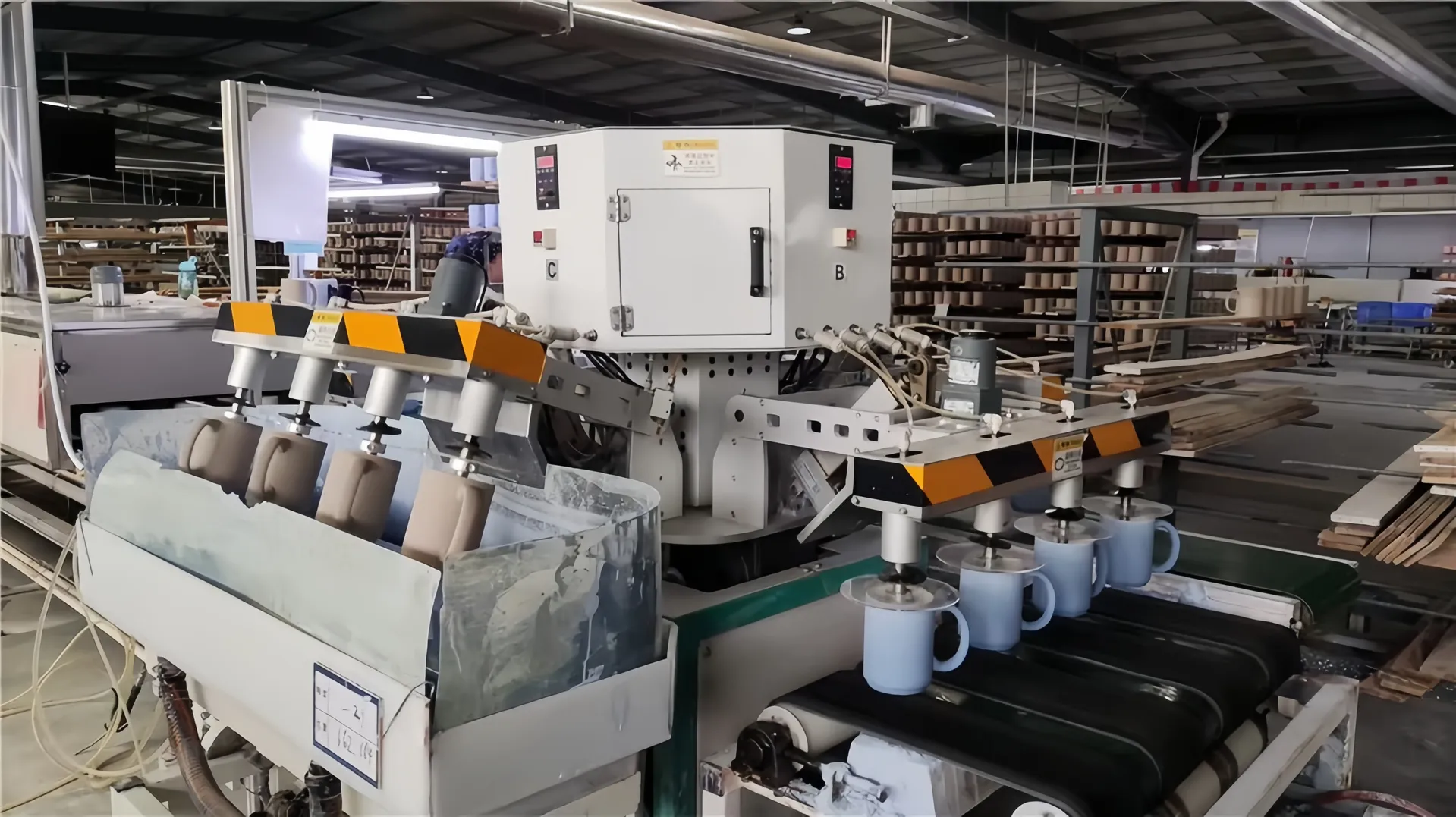 A ceramic manufacturing machine in a factory setting with shelves of ceramic items in the background.