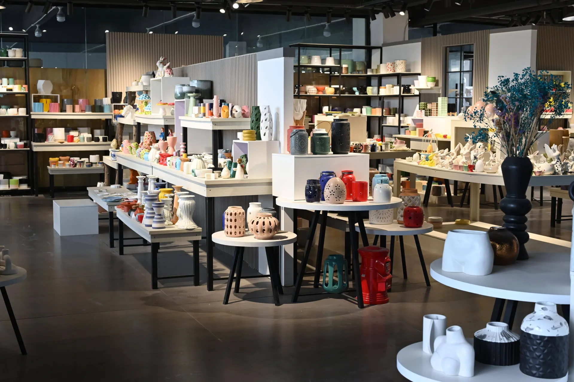 A store interior showcasing a variety of ceramic items in different colors and shapes displayed on shelves and tables.