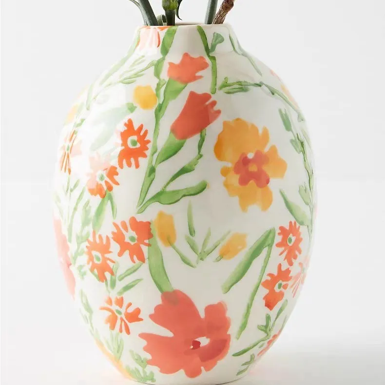 White vase with orange and yellow floral design.