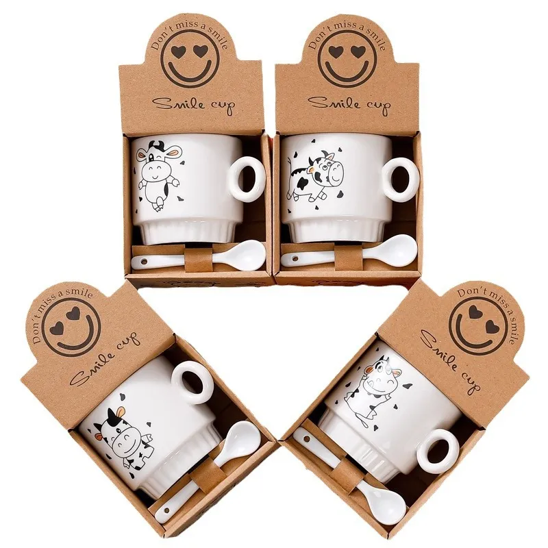 Set of four ceramic cups with cow illustrations, each in a box labeled 'Smile cup' and accompanied by a spoon.