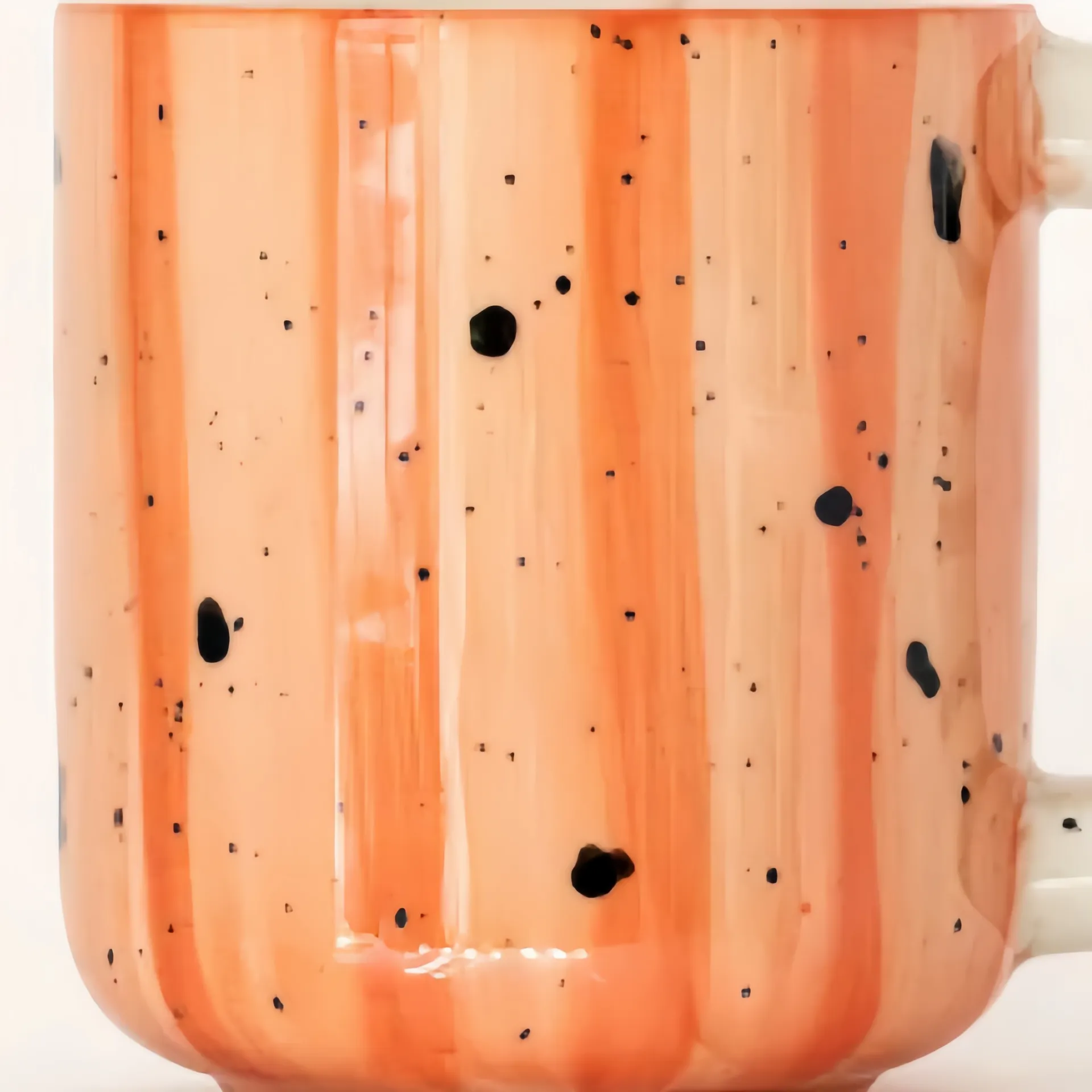 Close-up of an orange ceramic mug with black speckles.