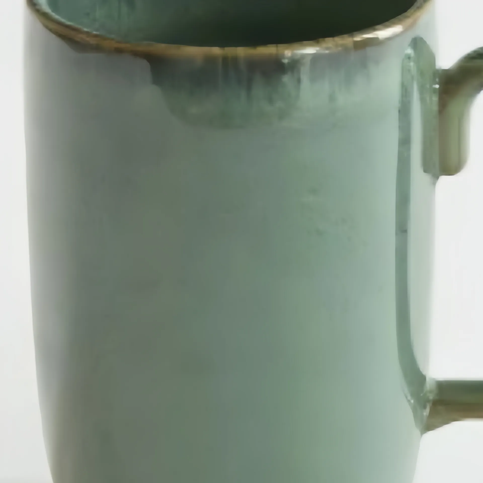 Close-up of a teal ceramic mug with a handle and a slightly textured surface.