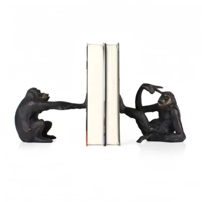 Zwei affenförmige Buchstützen, die ein Paar Bücher aufrecht halten.